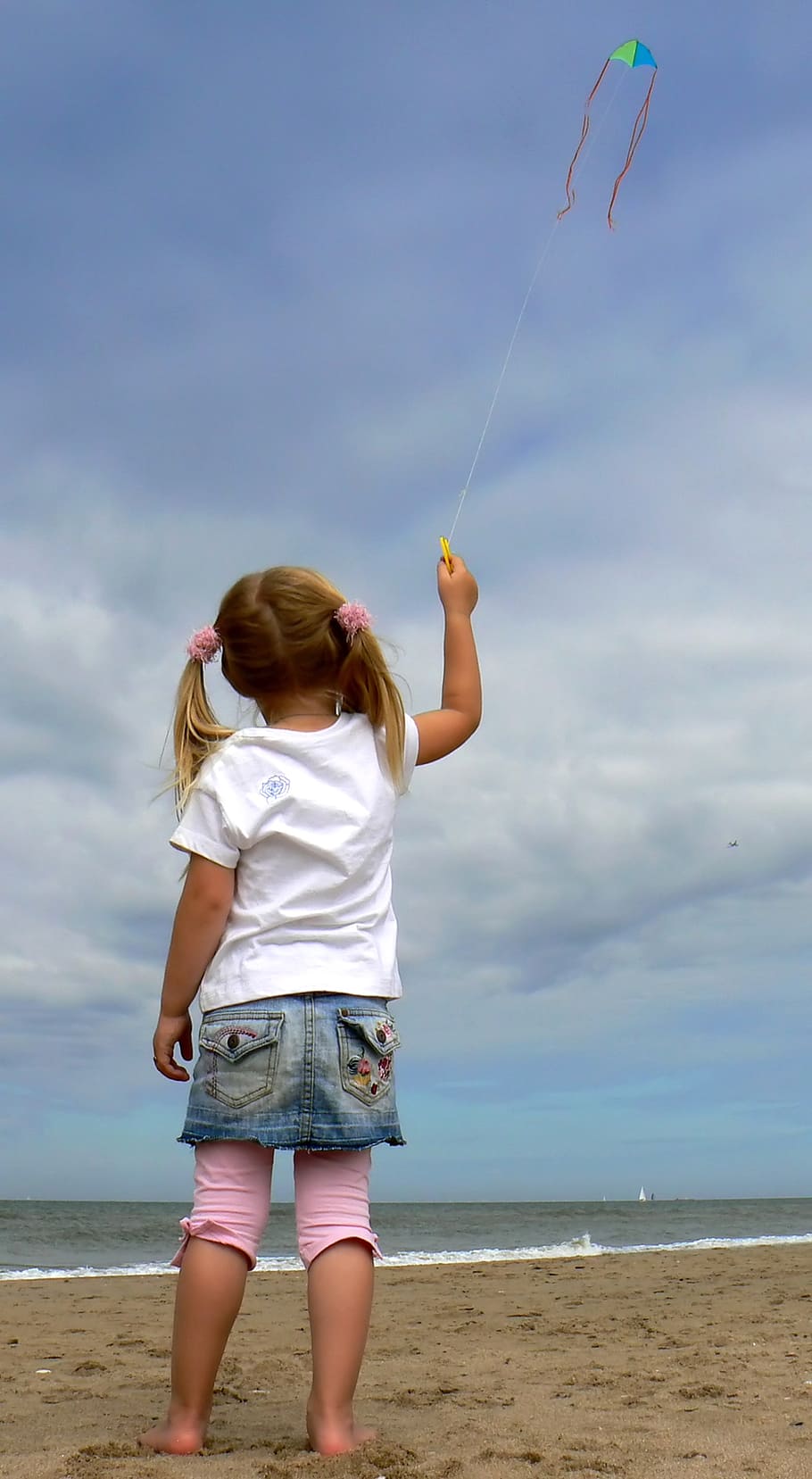 girl, holding, string, kite, flying, white, cloudy, sky, seashore, daytime