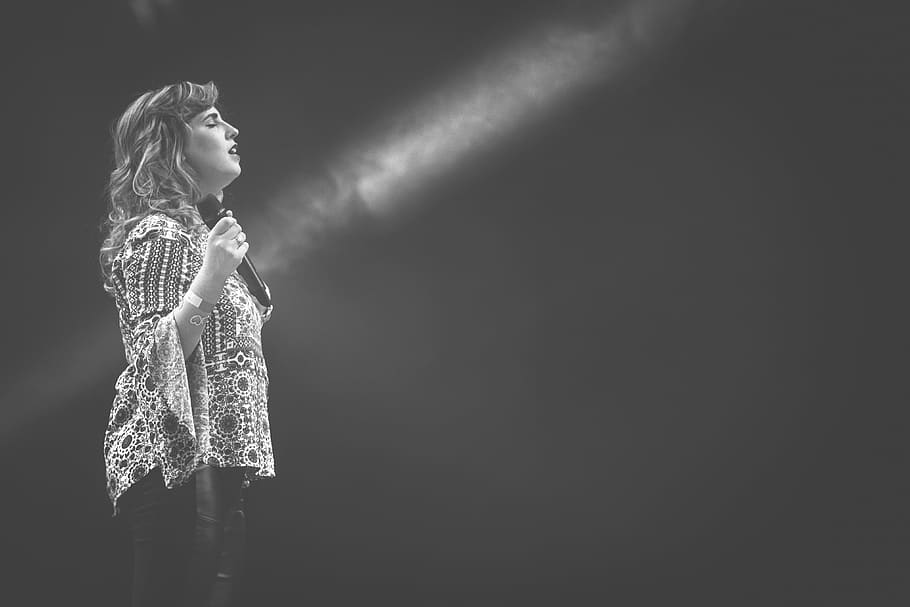 woman, holding, microphone, standing, people, dark, spotlight, singing, women, one person