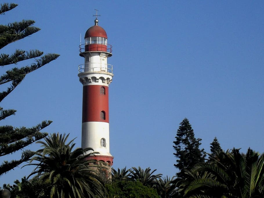 lighthouse, red, white, tall, tapered, green trees, blue sky, clear day, outdoors, tower