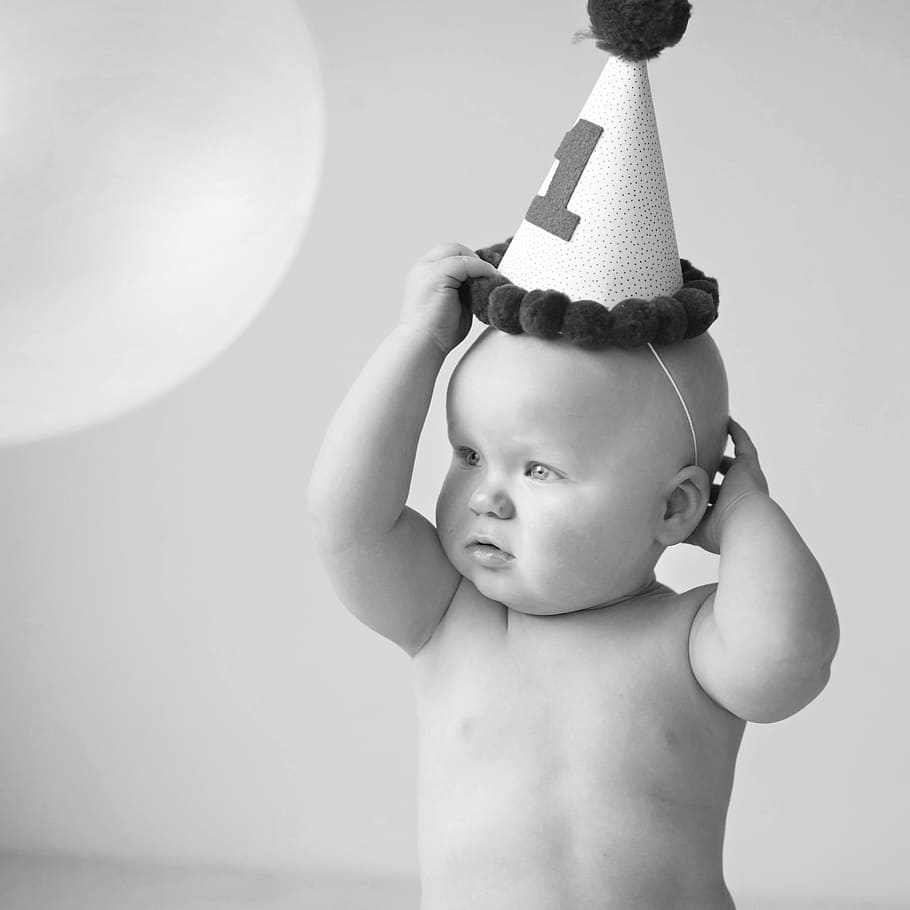 foto em tons de cinza, bebê, vestindo, chapéu de festa, menino, aniversário, criança, infância, sem camisa, uma pessoa