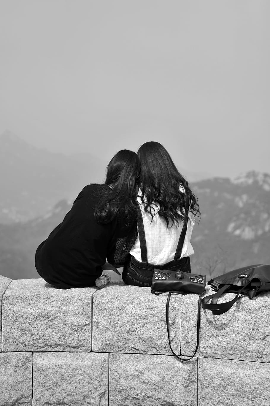 foto em escala de cinza, duas, mulheres, sentado, parede de bloco de concreto, amigos, amizade, isolado, assistir novamente, preto e branco