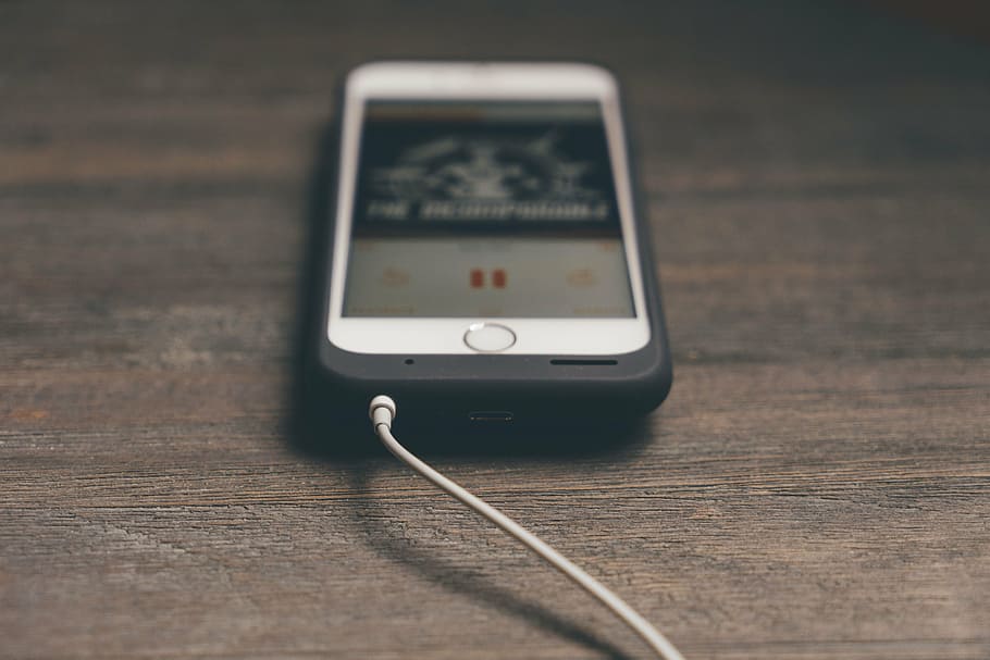 iphone ligado, exibindo, leitor de música, marrom, de madeira, superfície, telefone, telefone celular, maçã, branco