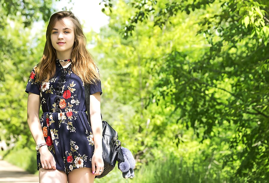 smiling, woman, wearing, blue, multicolored, floral, rompers, trees, daytime, summer