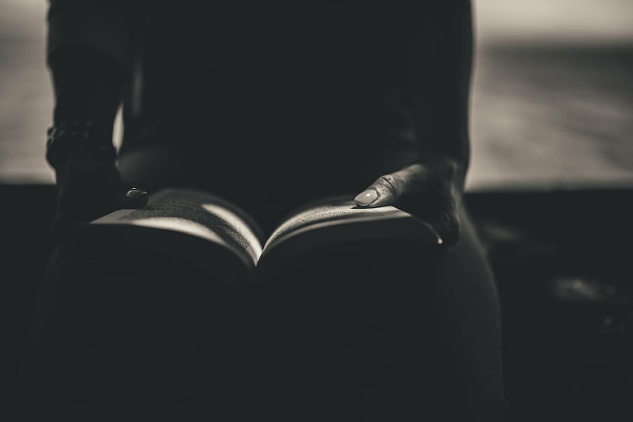 person reading book, silhouette, person, sitting, holding, book, reading, black and white, close-up, indoors