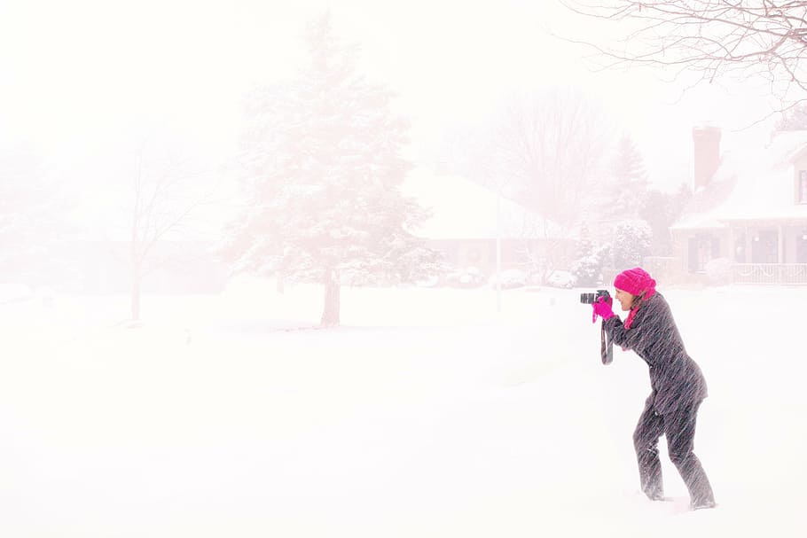 mujer, vistiendo, negro, abrigo, blanco, tenencia, cámara, medio, tormenta de nieve, fotógrafo