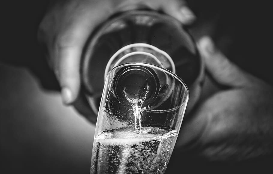 grayscale photo, person, holding, bottle, filling, clear, glass, prosecco, wine, brindisi