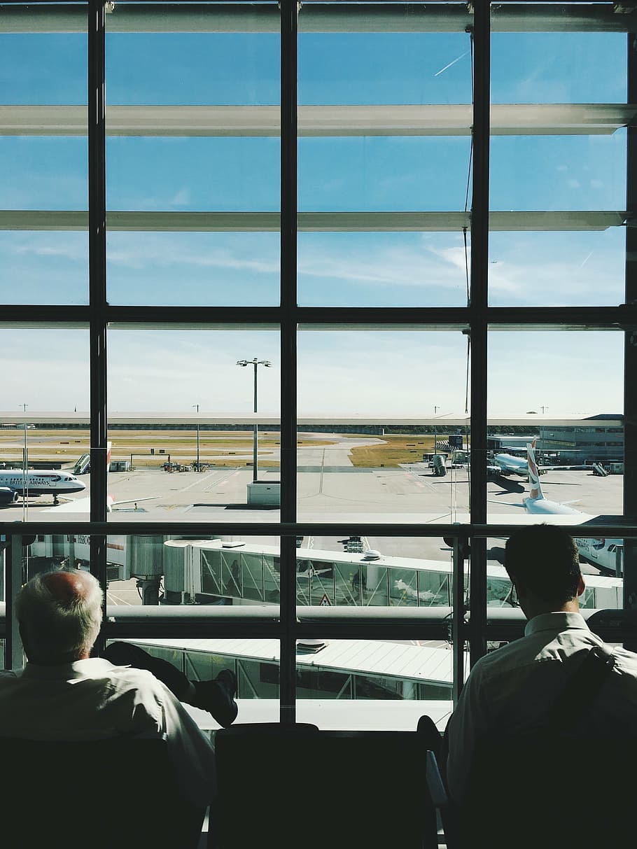 dois, pessoa, olhando, janela, aeroporto, enfrentando, painel, pessoas, homens, esperando
