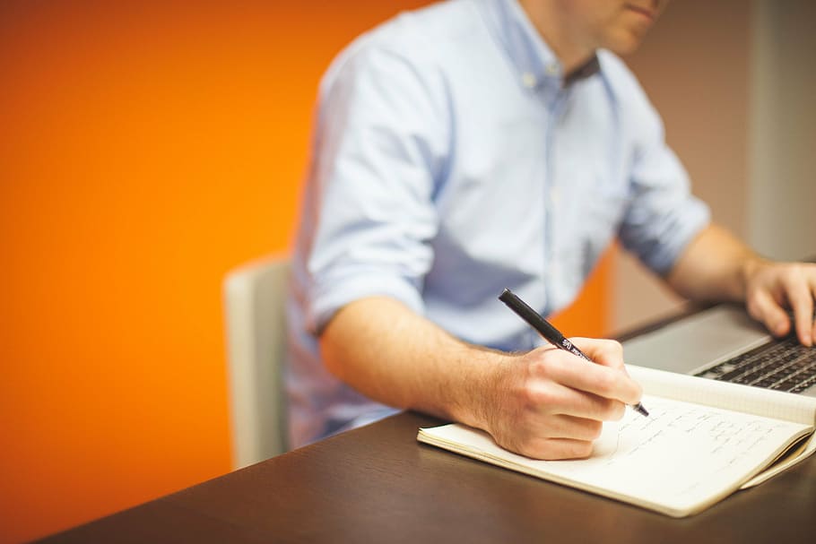 man, writing, using, laptop, table, holding, black, pen, sitting, white