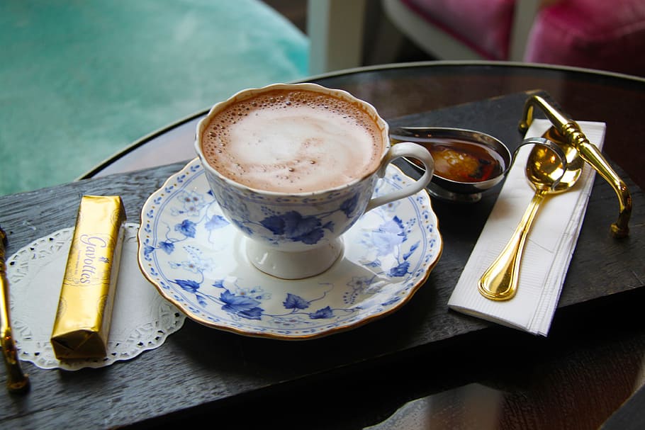 white, blue, floral, ceramic, teacup, filled, coffee, chocolate bar, gold-colored spoon, hot