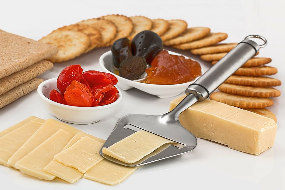 crackers and cheese, cheese slicer, crackers, appetizers, dairy product, protein, finger food, snack, hors d'oeuvre, sliced