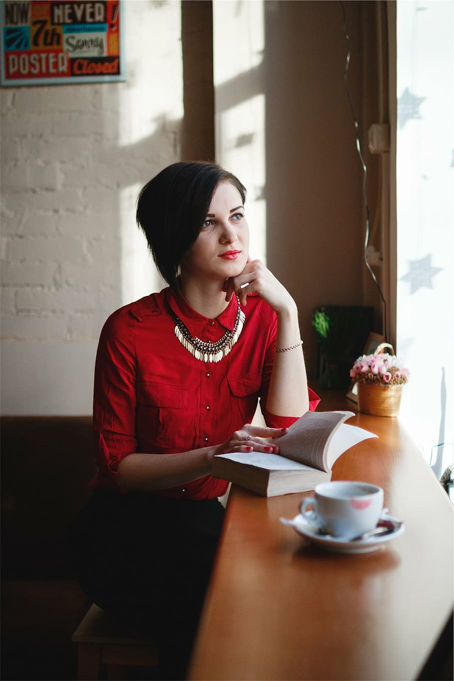 woman, sitting, reading book, coffee, table, wearing, red, long, sleeve, dress