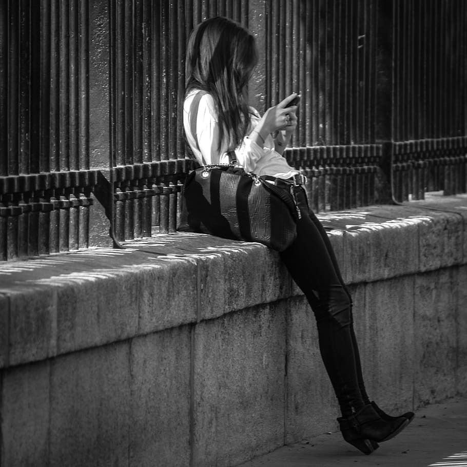 woman, using, smartphone, leaning, wall, paris, street, jardin du luxembourg, young woman, perspective