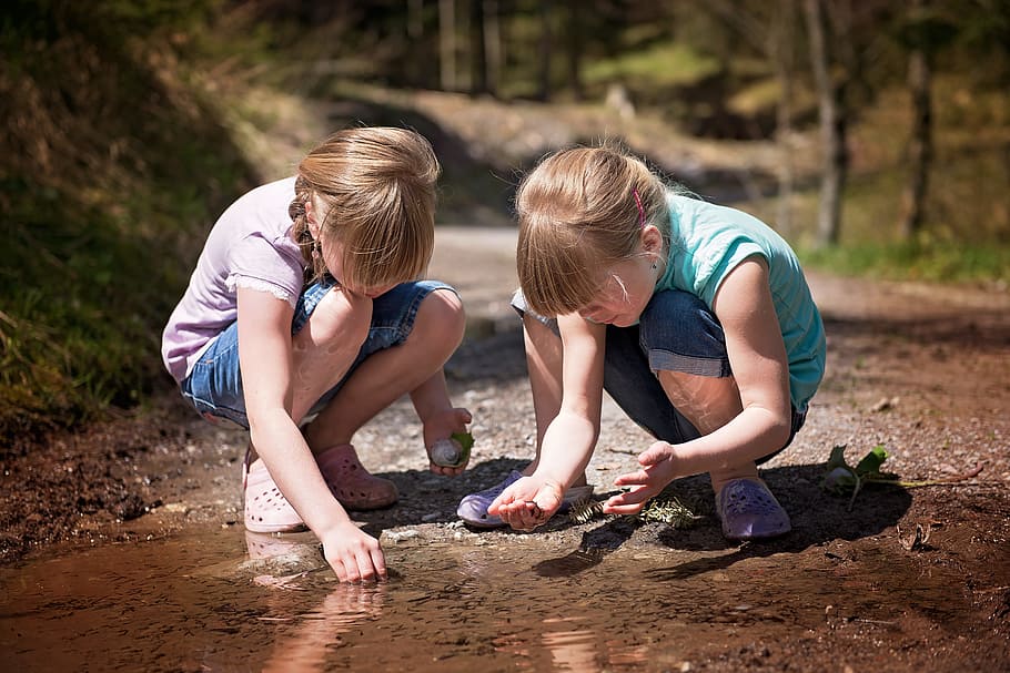 two girls crouching, children, girl, water-based paints, puddle, water, tadpoles, explore, nature, childhood