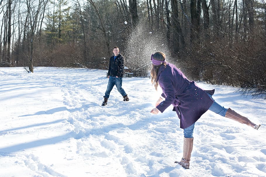 hombre, mujer, jugando, afuera, invierno, pelea de bolas de nieve, nieve, joven, al aire libre, pareja