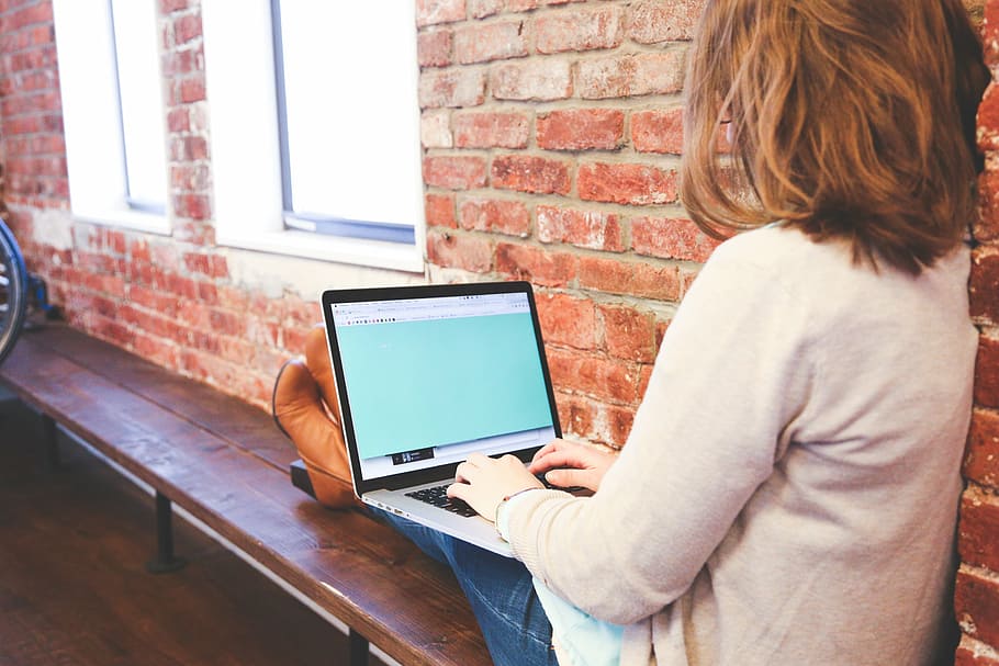 woman, sitting, using, laptop, holding, black, gray, computer, typing, working
