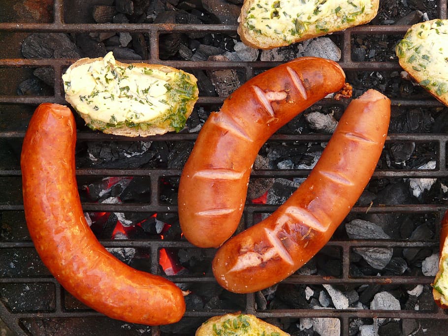 three grilled sausages, sausage, red sausage, bread, herb butter, barbecue, grill, embers, carbon, ash