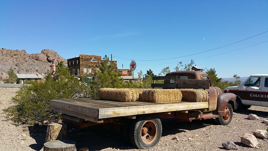 Flatbed Truck, Rust, flatbed truck with rust, old town background, old truck in foreground, hay bales on a truck by ghost town, blue sky over truck, near eldorado canyon nelson nevada, day, transportation