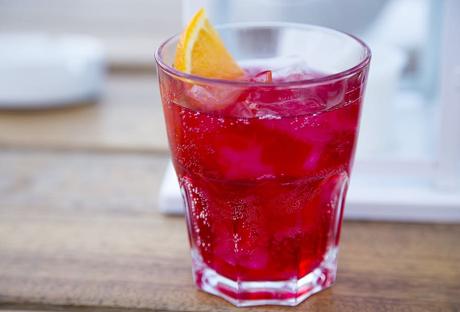 close-up photography, clear, drinking glass, pink-colored beverage, ice, sliced, lemon, campari soda, drink, alcohol