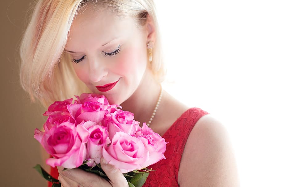 woman, wearing, red, scoop-neck sleeveless, top, holding, bouquet, pink, roses, blonde haired