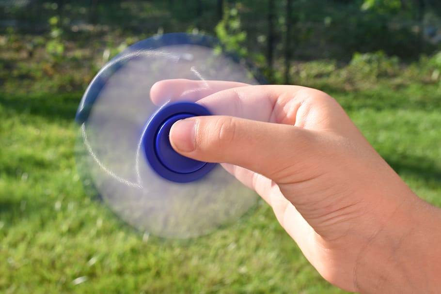 fidget spinner, spinning fidget, fidget, spinner, human body part, hand, human hand, one person, holding, grass