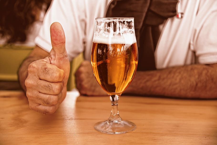 person, gesturing, thumbs, almost-filled cocktail glass, glass of beer, beer, glass, alcohol, drink, beverage