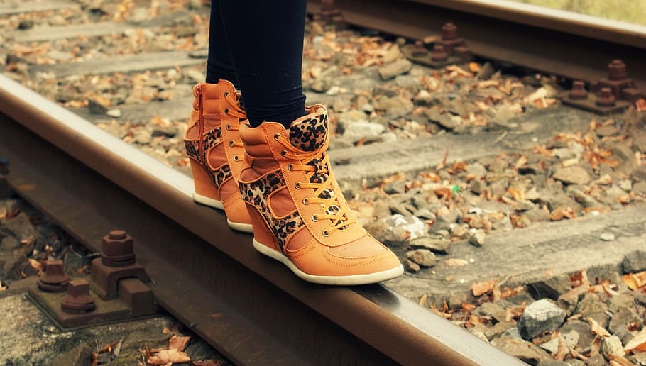 person, wearing, brown, leather wedge sneakers, train rail, boots, travel, track, architecture, shoe