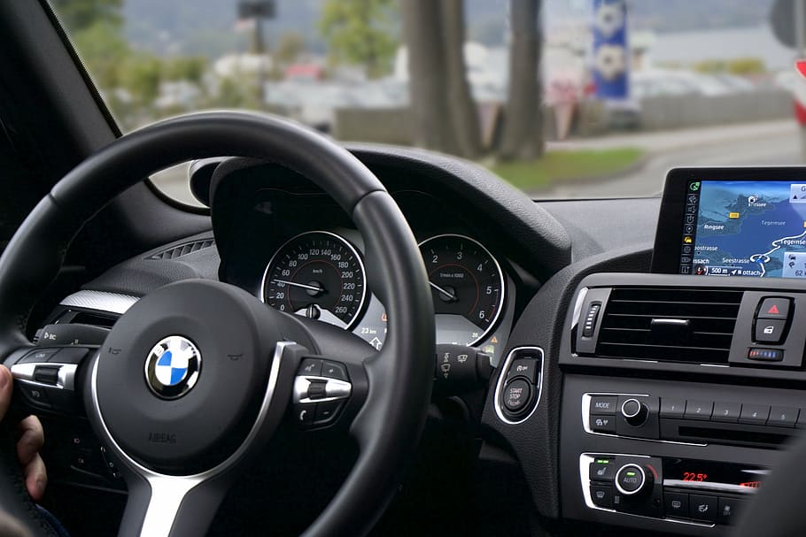 person, holding, black, bmw steering wheel, car, driving, route, interior, navigation, tachometer