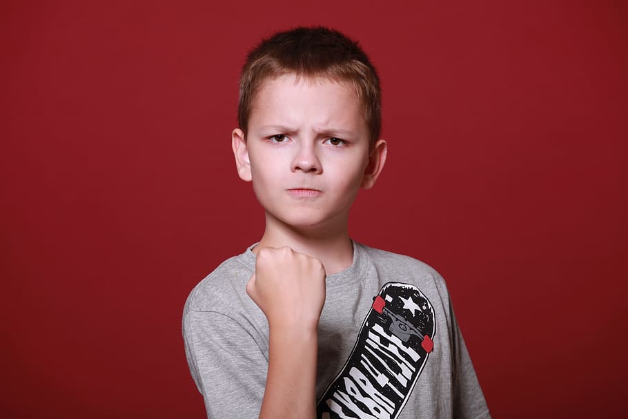 chico, rojo, camisa, mostrando, puño, adolescente, colegial, ira, enojado, amenazante