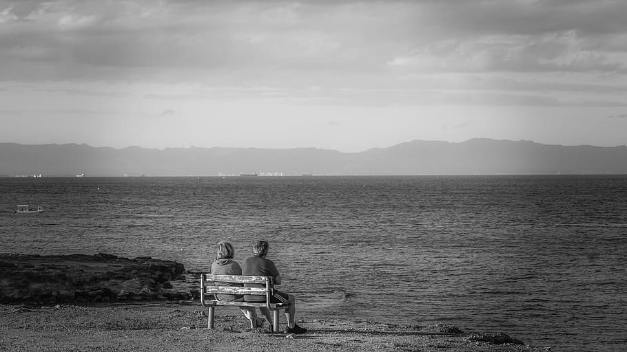 grayscale photo, two, persons, sitting, bench, next, body, water, couple, gazing