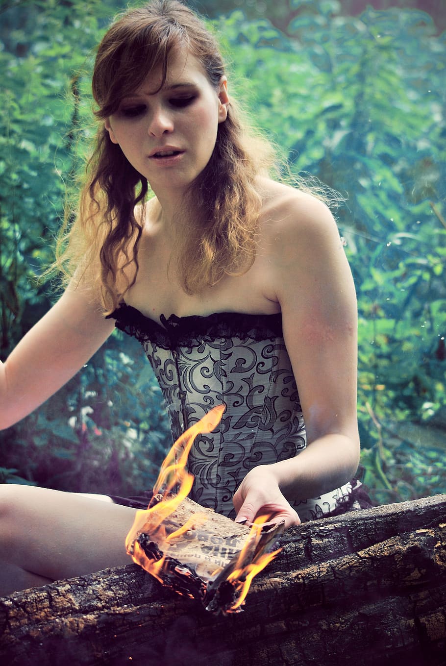 the girl conjures, kindles a fire, witch, burns the paper, koster, to build a fire, burned, burns, burning, fire