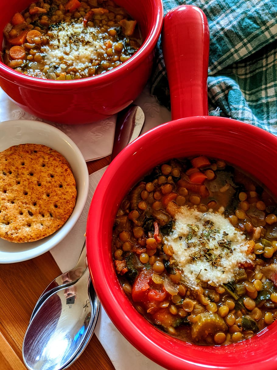lentil soup, soup, lentils, red bowls, dinner, vegetable soup, lunch, green napkin, spoons, food and drink