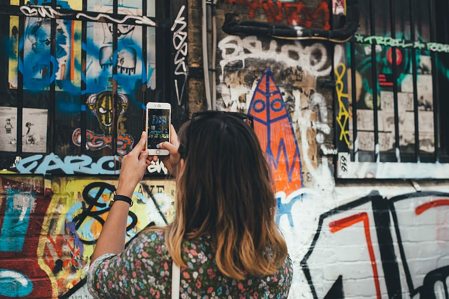 woman, black, floral, shirt, holding, silver iphone 6, taking, graffiti, woman in black, silver