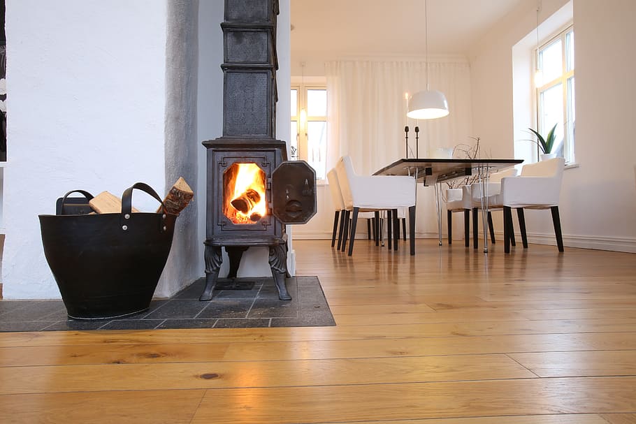 fireplace, cast iron fireplace, scandinavian design, indoors, wood, flooring, table, fire, lighting equipment, burning