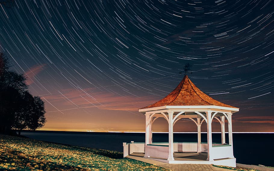 time lapse photo, wooden, canopy, body, water, star trails, milky way, pavilion, night, sky