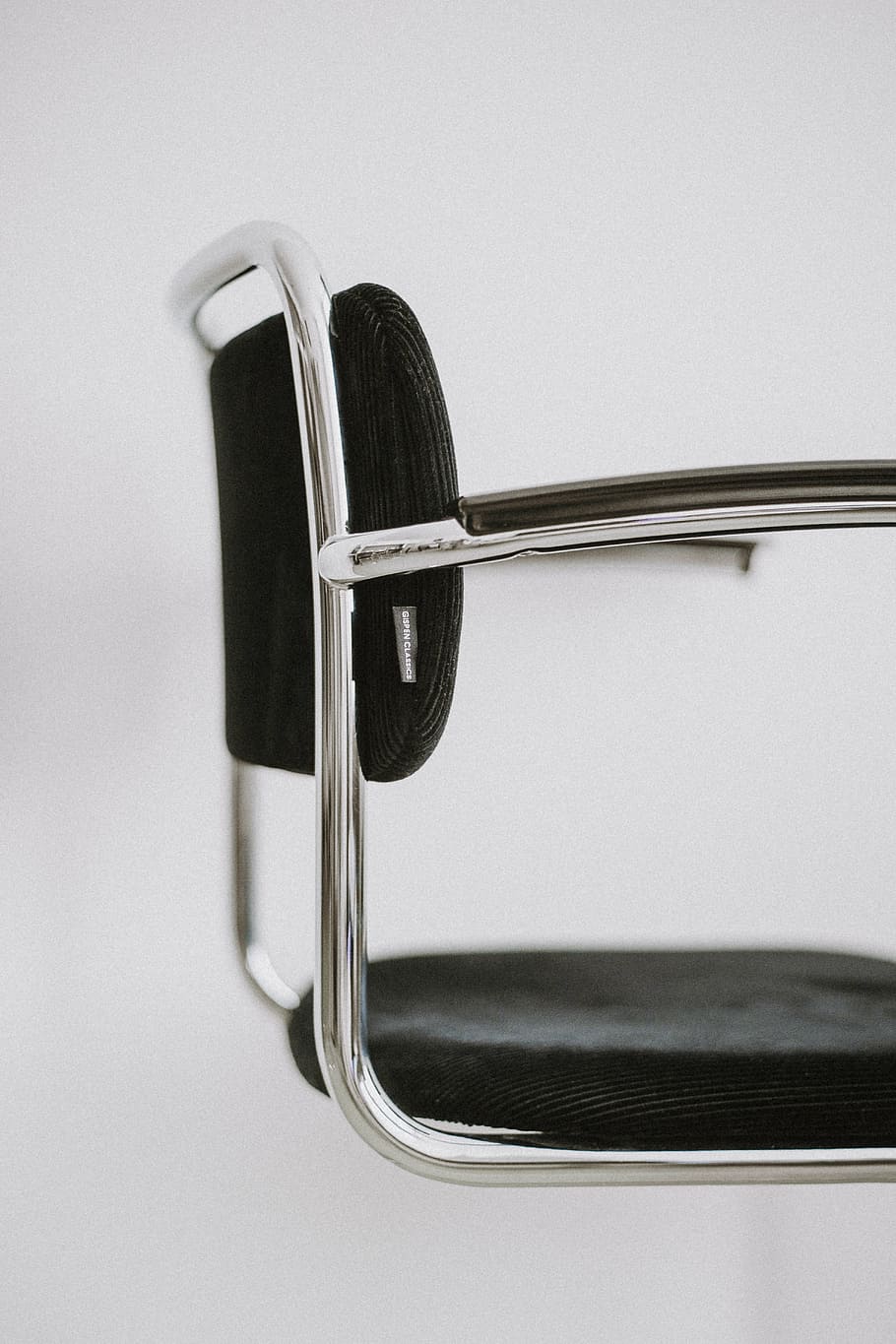 close-up photo, grey, black, cushion chair, chair, white, steel, wall, black and white, closeup