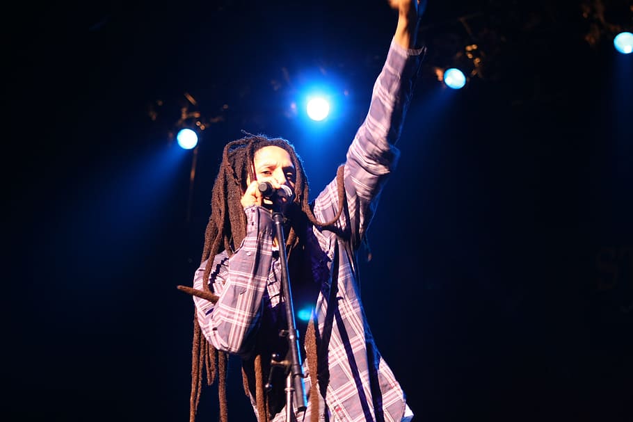 homem de cabelos dread-lock, em pé, segurando, microfone, estágio, Reggae, Cantor, Bob Marley, concerto, desempenho