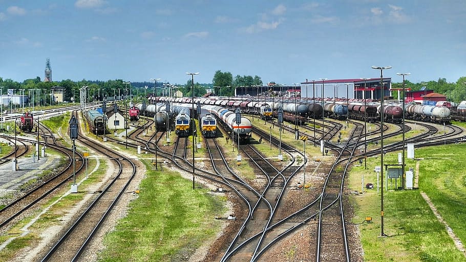 assorted-colors trains, clear, blue, sky, daytime, transport system, industry, train, railway line, travel