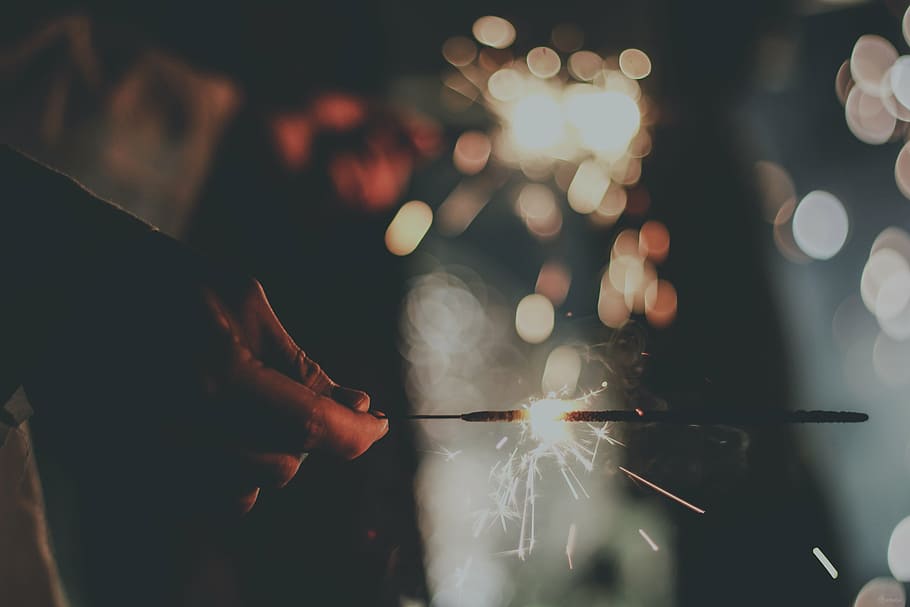 bokeh shot photo, bokeh, firework, hand, sparkler, adults only, night, adult, people, one person