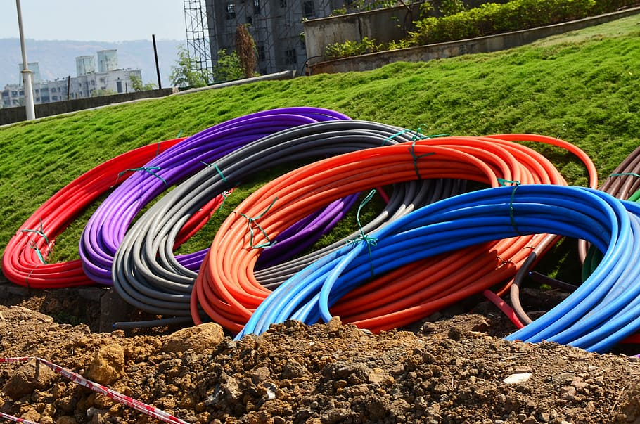 assorted-color hoses, green, grass field, conduit, pipes, coils, rolls, colours, digging, earth