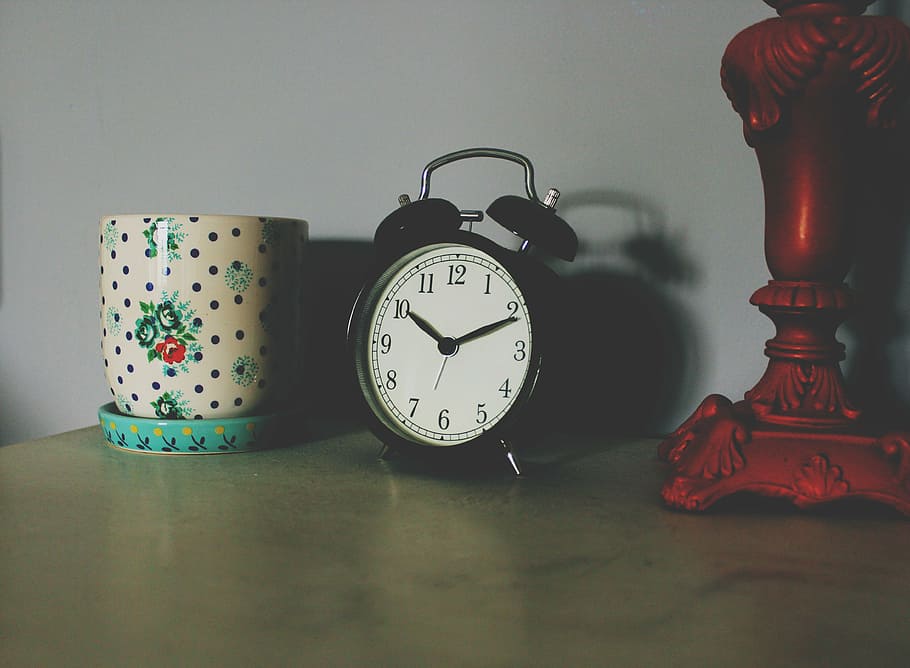 twin, bell alarm clock, displaying, 10:11, black, alarm, clock, white, vase, brown