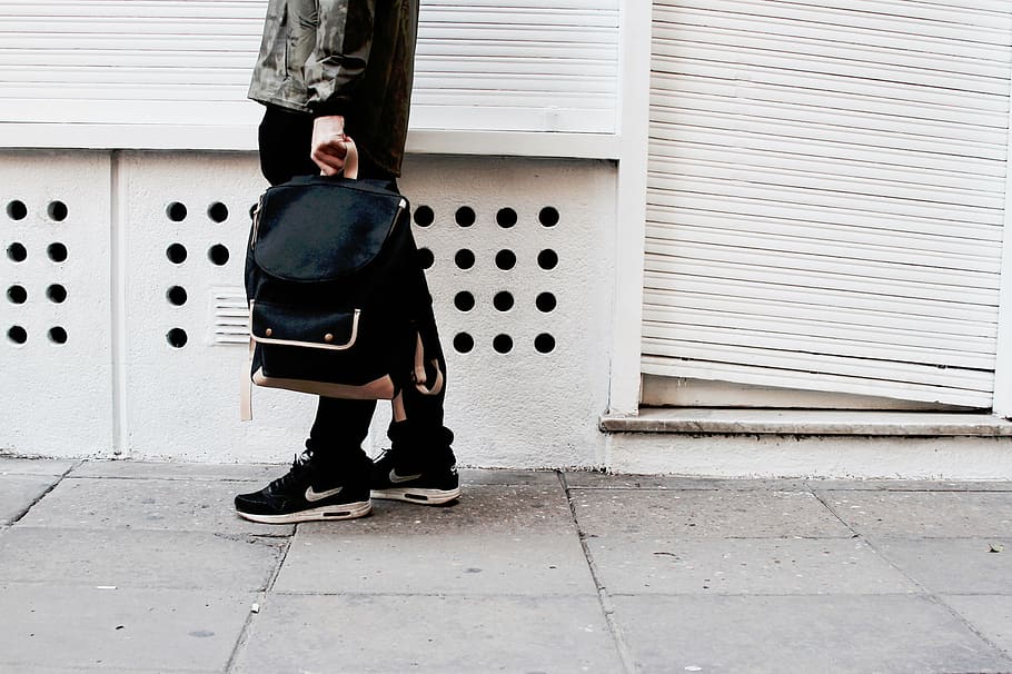 man, wearing, jacket, nike sneakers, holding, backpack, standing, wall, people, nike