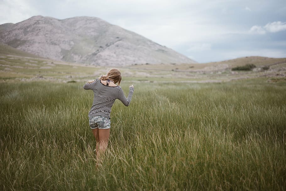 woman, walking, green, grass field, daytime, gray, long, sleeve, shirt, denim