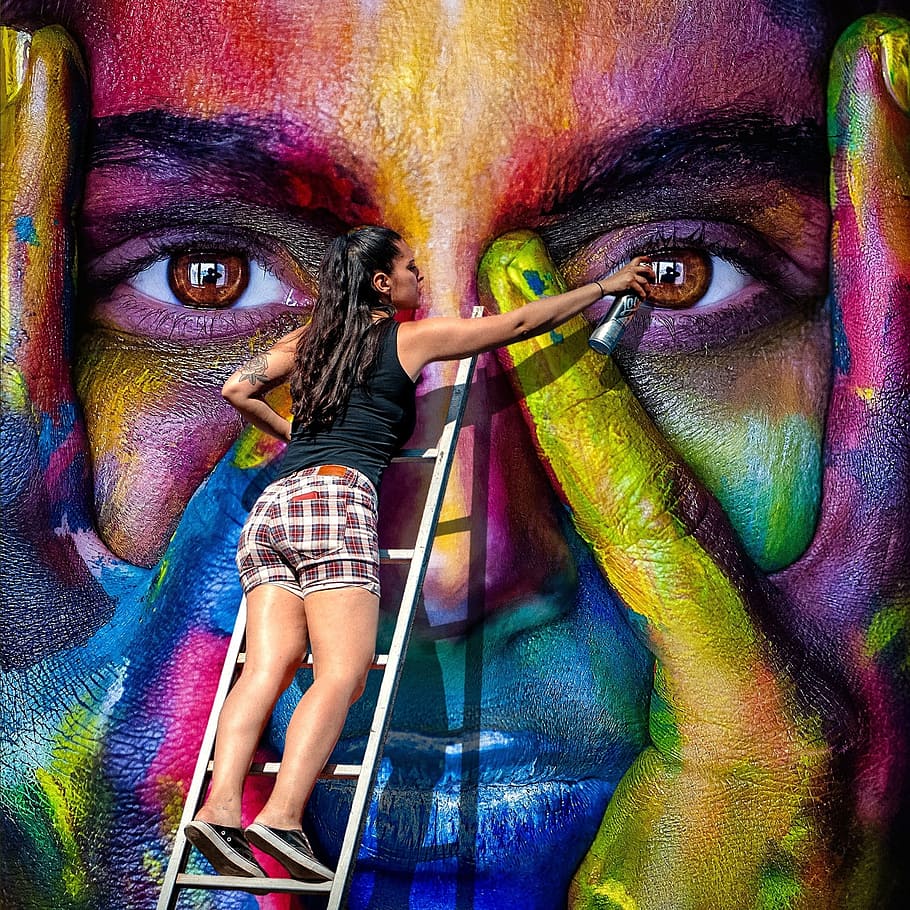 woman, wearing, black, sleeveless shirt, spray painting, street, daytime, wall art, spray, graffiti