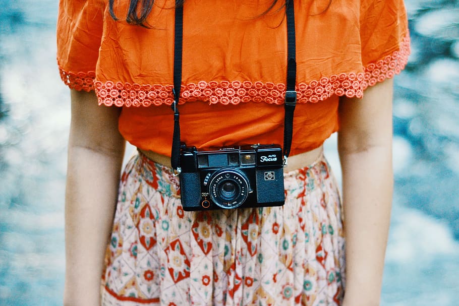 woman, orange, top, white, floral, bottoms, black, compact, film camera, camera