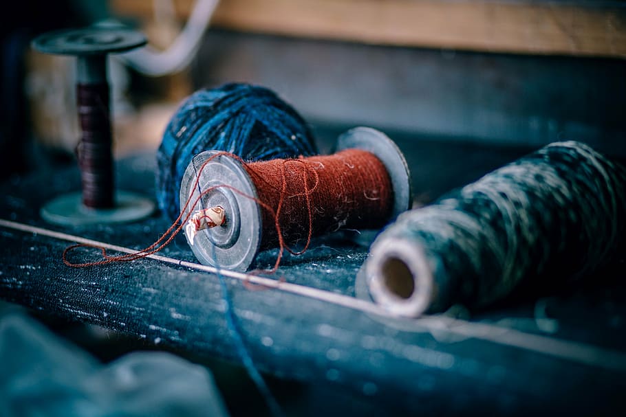 threads on wood, yarn, red, sew, clothing, tie, industry, spool, indoors, close-up