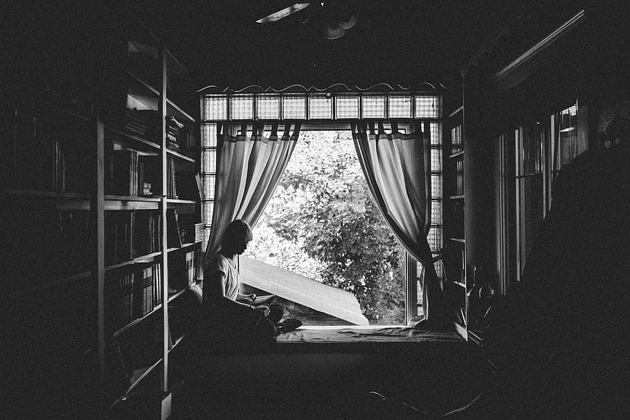 grayscale photo, woman, sitting, bed, window, grayscale, reading, book, near, windows