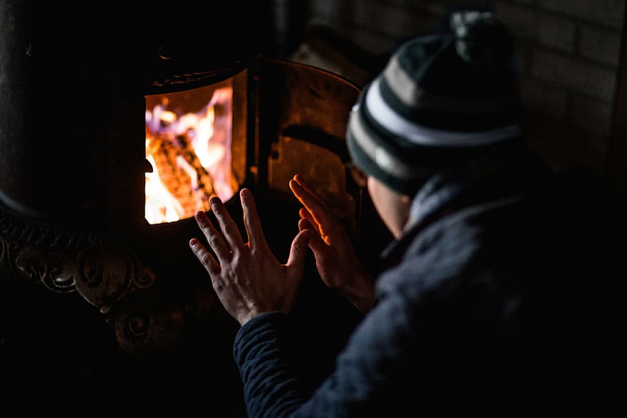 person, lighted, fireplace, people, man, cold, weather, bonnet, jacket, dark