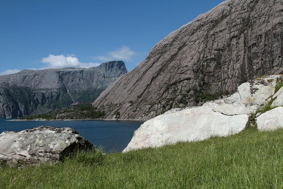 gray, cliff, grass, daytime, body, water, near, mountain, clouds, sky