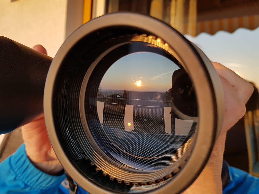 sunset, binoculars, mirror, reflections, perspective, sun, sky, one person, human body part, focus on foreground