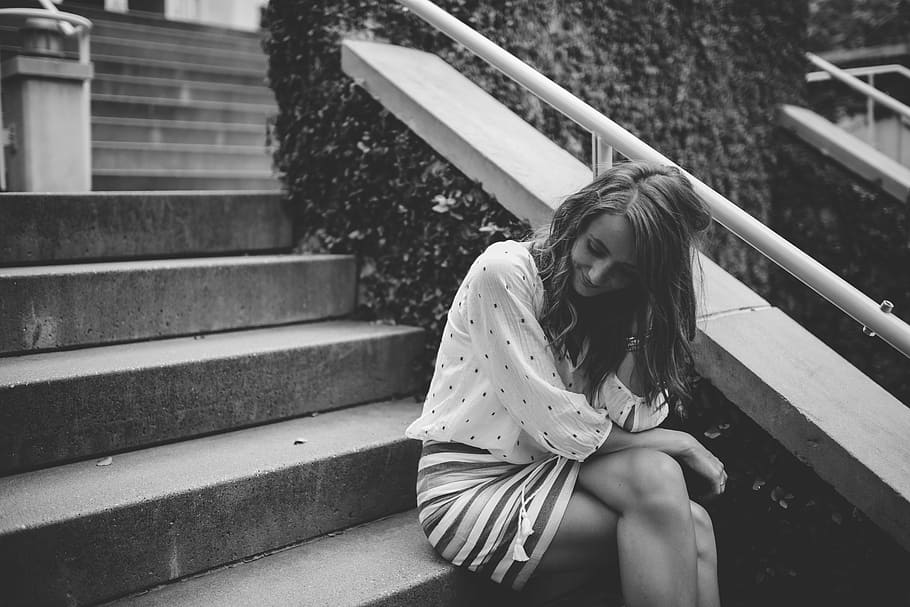 grayscale photo, woman, sitting, stairs, smiling, black and white, young, person, female, caucasian